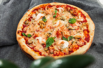 Seafood Italian pizza with shrimp,squid, mussels, fresh herbs and mozzarella on a crusty base viewed from above on Gray background. Horizontal photo.