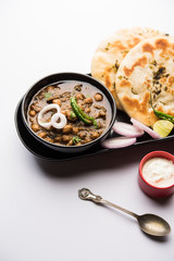 Pindi Chole Kulche or roadside choley Kulcha popular in India and pakistan is a popular streetfood. It's a spicy Chickpea or chana curry served with Indian Flat Bread. selective focus
