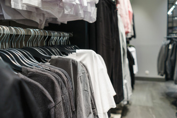 Fashionable clothes on hangers in a store.