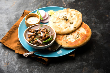 Pindi Chole Kulche or roadside choley Kulcha popular in India and pakistan is a popular streetfood. It's a spicy Chickpea or chana curry served with Indian Flat Bread. selective focus