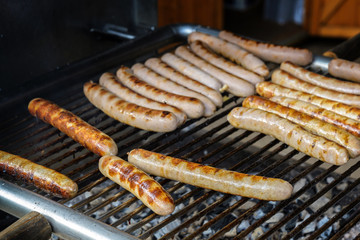 Many fried sausages on the charcoal grill, typical fast food in Germany on the street or at an open air festival