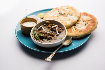 Pindi Chole Kulche or roadside choley Kulcha popular in India and pakistan is a popular streetfood. It's a spicy Chickpea or chana curry served with Indian Flat Bread. selective focus
