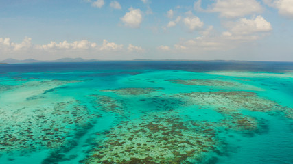 Tropical islands with coral reefs in the blue water of the sea, aerial view. Balabac, Palawan, Philippines. Summer and travel vacation concept.