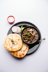 Pindi Chole Kulche or roadside choley Kulcha popular in India and pakistan is a popular streetfood. It's a spicy Chickpea or chana curry served with Indian Flat Bread. selective focus