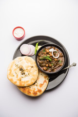 Pindi Chole Kulche or roadside choley Kulcha popular in India and pakistan is a popular streetfood. It's a spicy Chickpea or chana curry served with Indian Flat Bread. selective focus