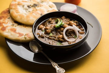 Pindi Chole Kulche or roadside choley Kulcha popular in India and pakistan is a popular streetfood. It's a spicy Chickpea or chana curry served with Indian Flat Bread. selective focus