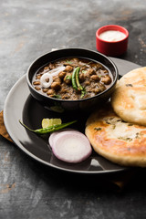 Pindi Chole Kulche or roadside choley Kulcha popular in India and pakistan is a popular streetfood. It's a spicy Chickpea or chana curry served with Indian Flat Bread. selective focus