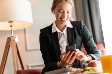 Blonde business woman sit indoors have a dinner.