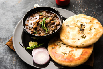 Pindi Chole Kulche or roadside choley Kulcha popular in India and pakistan is a popular streetfood. It's a spicy Chickpea or chana curry served with Indian Flat Bread. selective focus