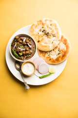 Pindi Chole Kulche or roadside choley Kulcha popular in India and pakistan is a popular streetfood. It's a spicy Chickpea or chana curry served with Indian Flat Bread. selective focus