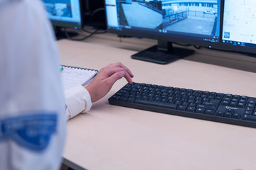 Security guard monitoring modern CCTV cameras in surveillance room. Female security guard in surveillance room.