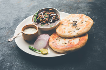 Pindi Chole Kulche or roadside choley Kulcha popular in India and pakistan is a popular streetfood. It's a spicy Chickpea or chana curry served with Indian Flat Bread. selective focus