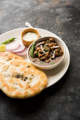 Pindi Chole Kulche or roadside choley Kulcha popular in India and pakistan is a popular streetfood. It's a spicy Chickpea or chana curry served with Indian Flat Bread. selective focus