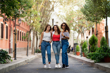 Fototapeta na wymiar Three female friends laughing in the street