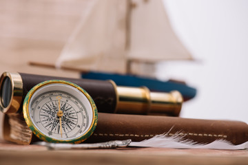 compass near leather copy book and telescope
