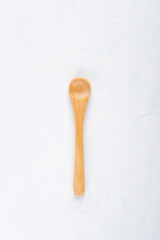 Empty new clean small bamboo wooden spoon on white table background top view flat lay.