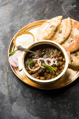Pindi Chole Kulche or roadside choley Kulcha popular in India and pakistan is a popular streetfood. It's a spicy Chickpea or chana curry served with Indian Flat Bread. selective focus