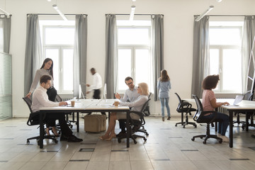 Busy diverse employees working in modern office coworking room