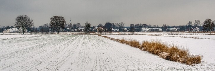 zimowy krajobraz pola i wioski na Śląsku, domy, gospodarstwa o pole pokryte śniegiem