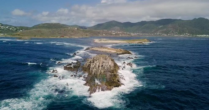 Stationary relaxing drone video of waves hitting the rocks in Saint Martin Sint Maarten