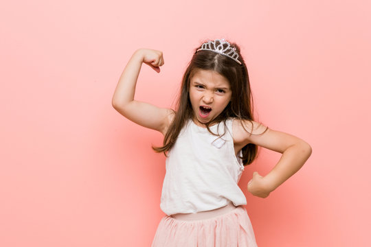 Little girl wearing a princess look raising fist after a victory, winner concept.