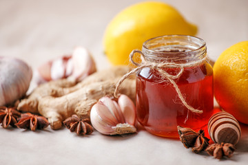 Ingredients for healthy tea with herbs, honey, ginger, garlic and lemon, seasonal traditional flu remedy drink, alternative medicine concept, homeopathy treatment