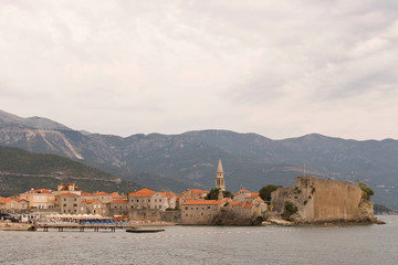 Old city by the sea with mountains in the background .