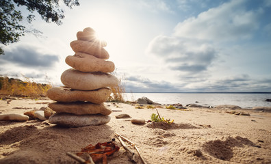 zen stones stacked at sea with backlight
