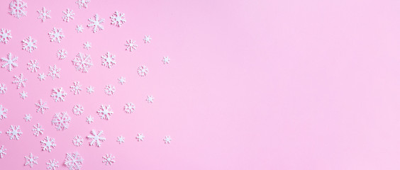 Winter composition. Christmas, new year concept. Top view. Flat lay. Winter pattern made of white snowflakes on pink background.