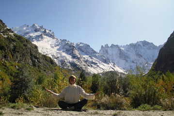 Fototapeta premium Woman meditating yoga in mountain gorge. Travel. Lifestyle. Relaxation. Emotional concept. Outdoor adventure. Harmony with nature.