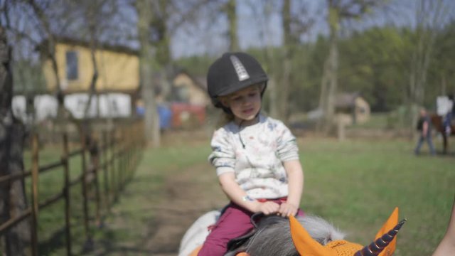 Unicorn pony animal and girl child riding it. Focus change. Gimbal motion