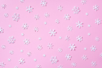 Winter pattern made of white snowflakes on pink background. Top view. Flat lay. Winter composition. Christmas, new year concept.