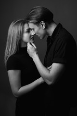 Young man and woman kissing in studio. Black and white