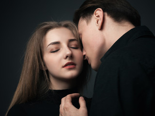 Young man and woman kissing in studio.