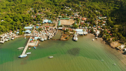 Fototapeta na wymiar Village of stilt houses built over the sea, top view. City and port on Balabac Island, Palawan, Philippines.