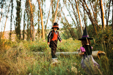 Two children disguised for Halloween in the woods