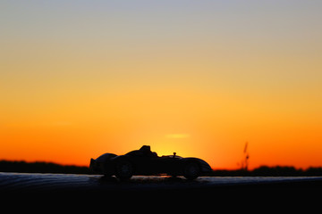Car on a sunset background. Beautiful landscape. Car in the shade