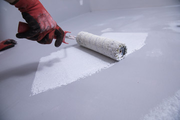 close up of male in gloves painting a wall