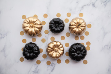 Luxury gold and black autumn pumpkin flat lay composition on a marble background