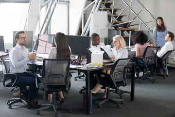 Busy multi racial office employees working in coworking shared room