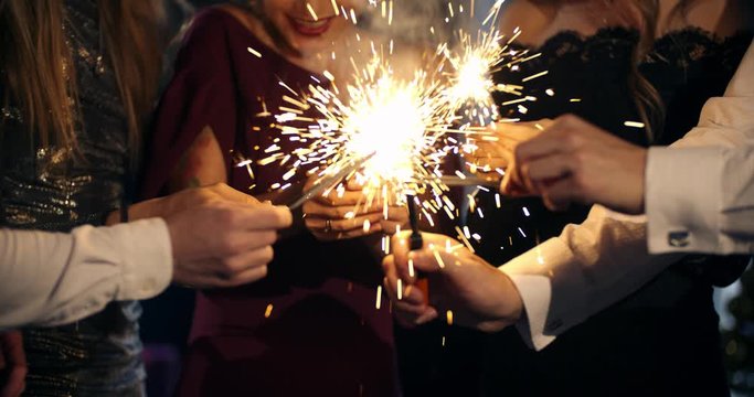 group of people burn sparklers, waving sparklers celebrating for birthday and new year, Christmas. friendship, vacation, lifestyle, advertising, commercial concept. close shot. sinematic camera
