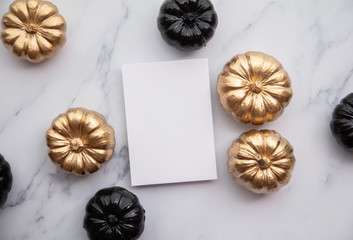 Luxury gold and black autumn pumpkin flat lay composition on a marble background