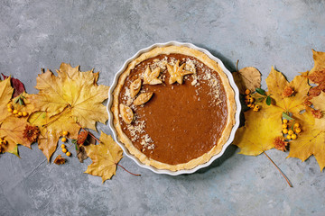 Traditional homemade autumn pumpkin pie for Thanksgiving or Halloween dinner served in ceramic dish...