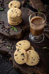 Сhocolate nut biscuit. Crispy and crumbly delicious cookies with natural ingredients: flour, nuts, seeds, pieces of chocolate, cocoa, fruit jams. Stylish still life for poster.
