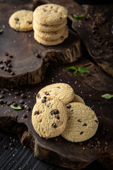 Сhocolate nut biscuit. Crispy and crumbly delicious cookies with natural ingredients: flour, nuts, seeds, pieces of chocolate, cocoa, fruit jams. Stylish still life for poster.