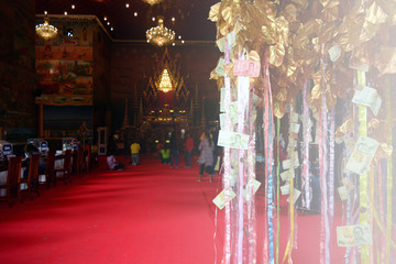 buddhist people make merit by hang banknote with the golden tree in the chapel of.famous temple in  NhongKai ,Thailand