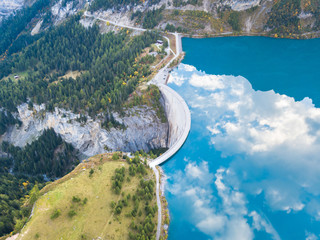 Water dam and reservoir lake in Swiss Alps to produce hydropower, hydroelectricity generation,...