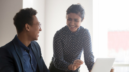 Happy diverse coworkers team laughing talking at office work
