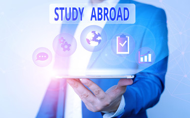 Handwriting text writing Study Abroad. Conceptual photo live in a foreign country and attend a foreign university Male human wear formal work suit presenting presentation using smart device