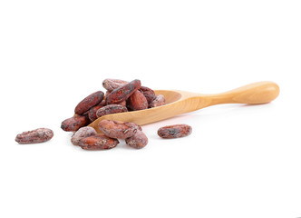 unpeeled cocoa beans in a wooden spoon on white